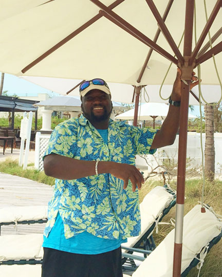 Delroy McIntosh exudes so much pride and joy as he tests the umbrellas around the pool.