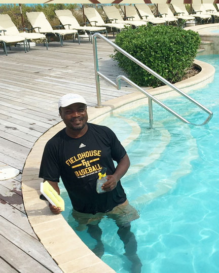 Eddy Joseph, pool and beach attendant is making sure those pool tiles in the main pool are sparkling!