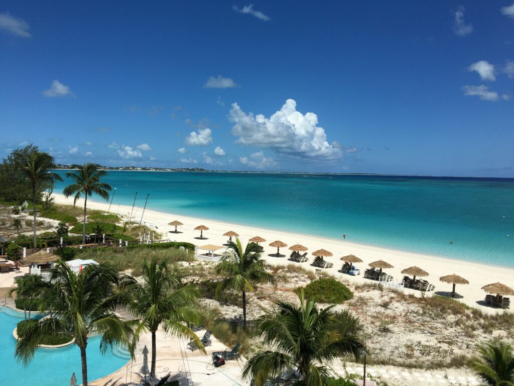 View of the sands beach with palapas and corner of pool