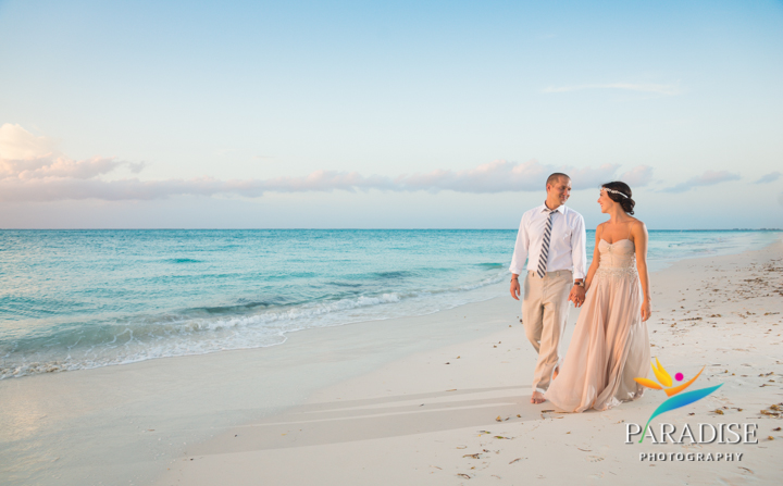 Wedding couple holding hands walking on the beach