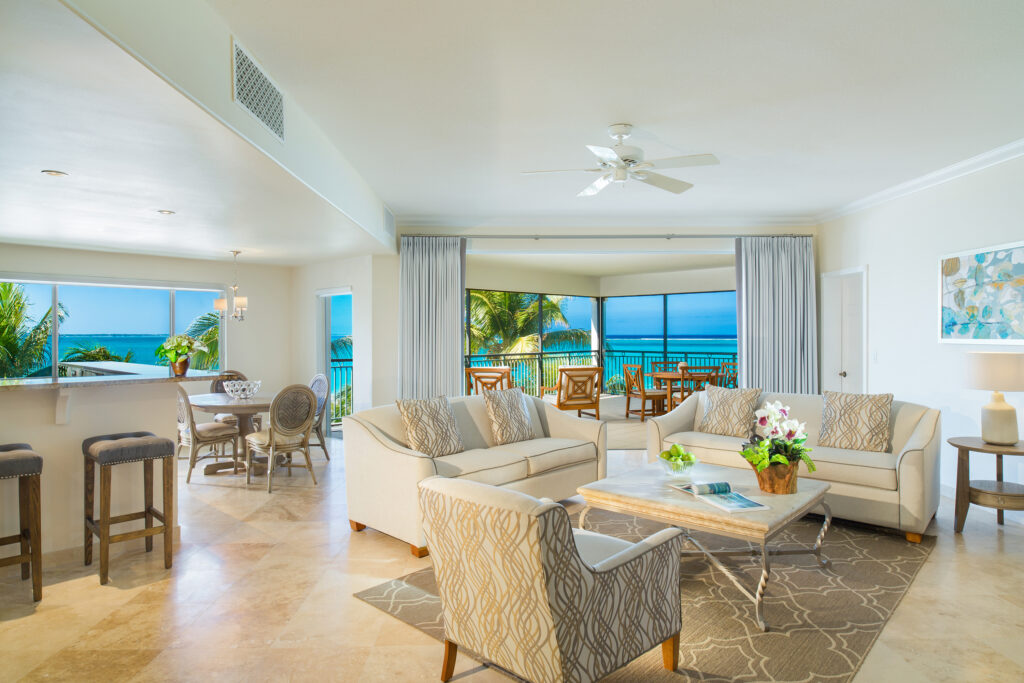 Large living area with seating area, dining area, kitchen bar area, and large balcony